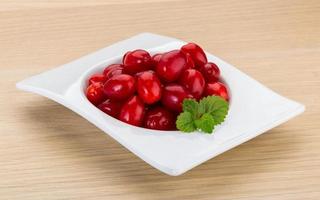 Cornus in a bowl on wooden background photo