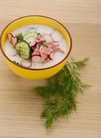 Okroshka in a bowl on wooden background photo