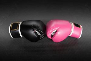 guante de boxeo rosa y negro en concepto de perforación en mujer. foto