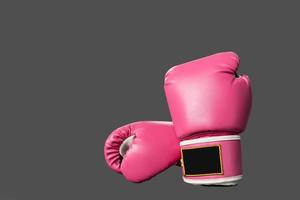 pink boxing gloves for girl and woman fight with copy space in dark background. photo