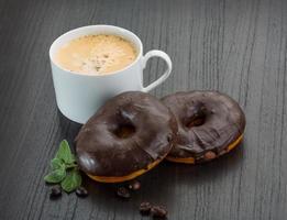 Coffee with Chocolate donuts on wooden background photo