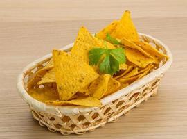 Nachos in a basket on wooden background photo