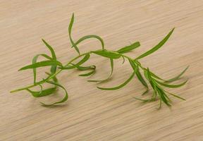 Tarragon leaves on wooden background photo