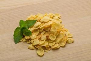 Corn flakes on wooden background photo