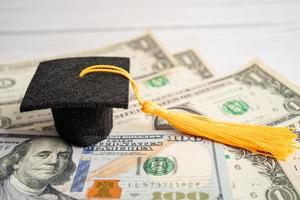 sombrero de la brecha de graduación en el dinero de los billetes en dólares estadounidenses, concepto de enseñanza de aprendizaje de la tarifa de estudio de educación. foto