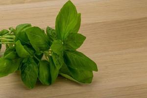 hojas de albahaca sobre fondo de madera foto