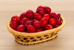 Cornus in a basket on wooden background photo