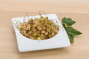 White currant in a bowl on wooden background photo