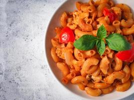 pasta de macarrones con salsa de tomate vista superior sobre una mesa de madera blanca con espacio para copiar foto