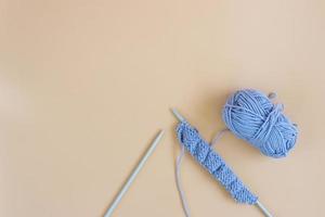 Top view of gray knitting wool and knitting needles on pastel orange background. photo