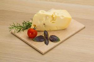 Maasdam cheese on wooden board and wooden background photo