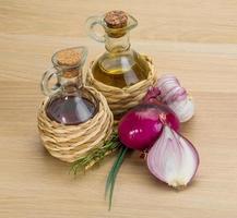 Oil, vinegar with onion on wooden background photo