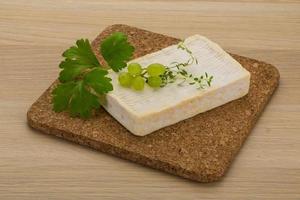 Brie cheese on wooden board and wooden background photo