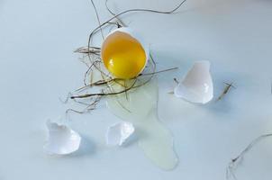 el huevo blanco está roto, la cáscara está sobre la mesa. fondo claro foto