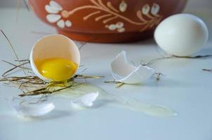 white egg is broken, the shell is on the table. Light background photo