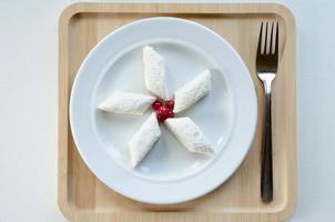 lazy dumplings on a plate, on a wooden tray with a fork. Light background photo