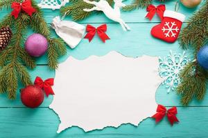 Christmas card with frame of winter accessories on blue wooden background.Top view and selective focus photo