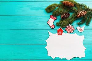 Frame of pine cones on a Christmas tree on blue wooden background. Top view photo