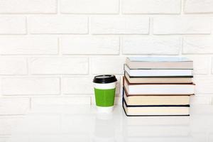 Education literature. Cup of coffee and books on the table in a class. Top view and copy space. Selective focus photo