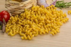 Fusilli on wooden background photo