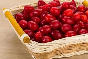 Cornus in a basket on wooden background photo