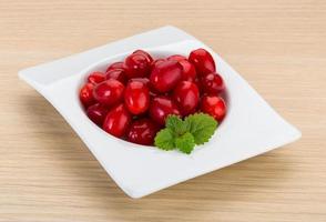 Cornus in a bowl on wooden background photo