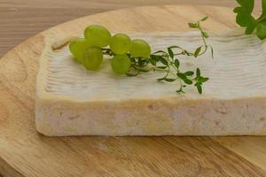 Brie cheese on wooden board and wooden background photo