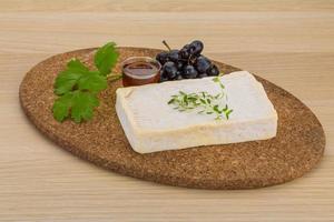 Brie cheese on wooden board and wooden background photo