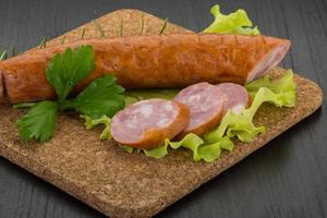 Sausage on wooden board and wooden background photo