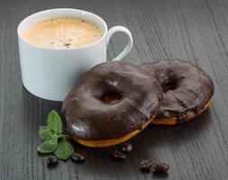 Coffee with Chocolate donuts on wooden background photo