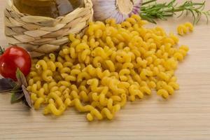 Fusilli on wooden background photo