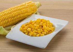 maíz dulce en un bol sobre fondo de madera foto