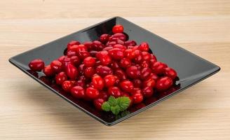 Cornus on the plate and wooden background photo