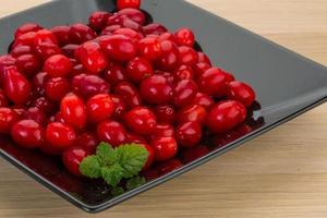 Cornus on the plate and wooden background photo