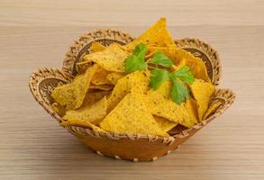 Nachos in a basket on wooden background photo