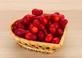 Cornus in a basket on wooden background photo