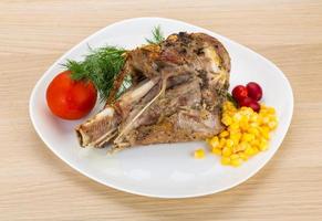 Roasted turkey leg on the plate and wooden background photo