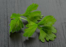 Celery leaves on wooden background photo