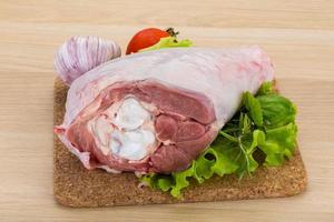 Turkey leg on wooden board and wooden background photo