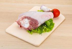 Turkey leg on wooden board and wooden background photo