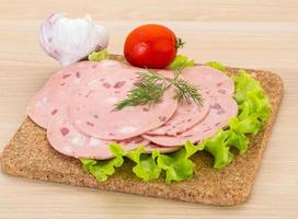 Beef sausage on wooden board and wooden background photo