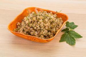 White currant in a bowl on wooden background photo