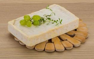 Brie cheese on wooden board and wooden background photo