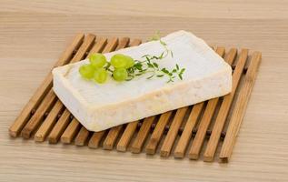 Brie cheese on wooden board and wooden background photo