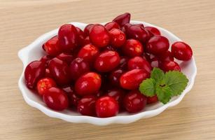 Cornus on the plate and wooden background photo