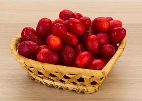 Cornus in a basket on wooden background photo