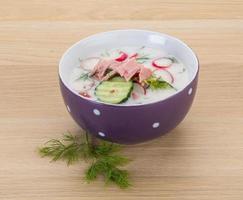 Okroshka in a bowl on wooden background photo