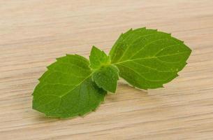 Mint leaves on wooden background photo