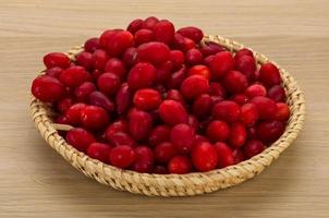 Cornus in a basket on wooden background photo