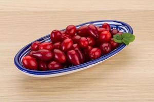 Cornus in a bowl on wooden background photo